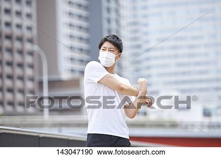 Stock Image - Young Japanese man training downtown Tokyo. Fotosearch