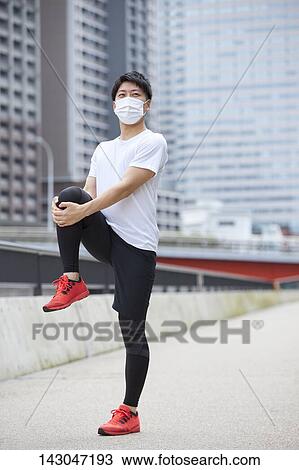 Stock Image - Young Japanese man training downtown Tokyo. Fotosearch