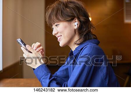 Stock Image - Young Japanese woman at a cafe. Fotosearch