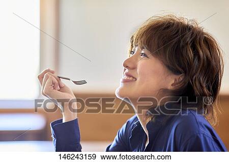 Stock Photo - Young Japanese woman at a cafe. Fotosearch