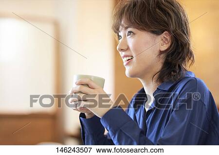 Stock Photo - Young Japanese woman at a cafe. Fotosearch