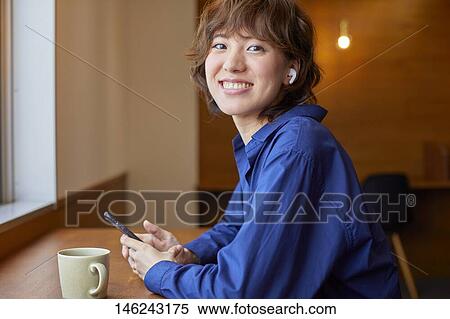 Stock Photography - Young Japanese woman at a cafe. Fotosearch