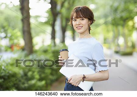 Stock Image - Young Japanese woman outside. Fotosearch