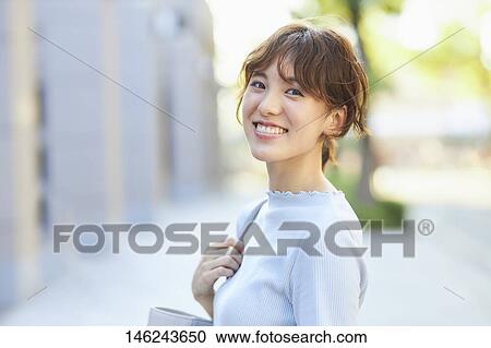 Stock Image - Young Japanese woman outside. Fotosearch
