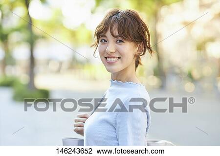 Stock Image - Young Japanese woman outside. Fotosearch