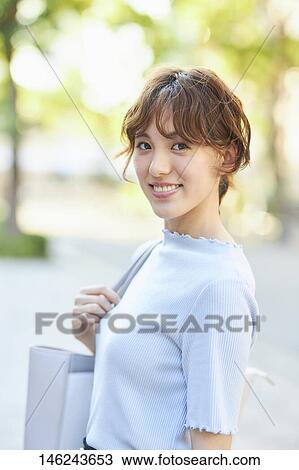 Stock Image - Young Japanese woman outside. Fotosearch