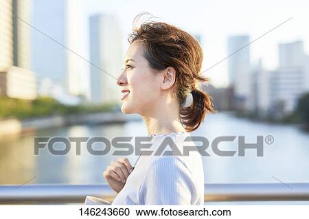 Stock Image - Young Japanese woman outside. Fotosearch