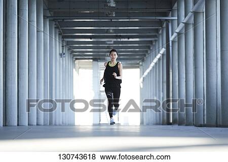Stock Photo - Young Japanese Woman Running Downtown Tokyo, Japan. Fotosearch