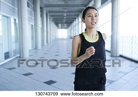 Stock Photo - Young Japanese Woman Running Downtown Tokyo, Japan. Fotosearch
