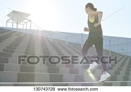 Stock Photo - Young Japanese Woman Running Downtown Tokyo, Japan. Fotosearch