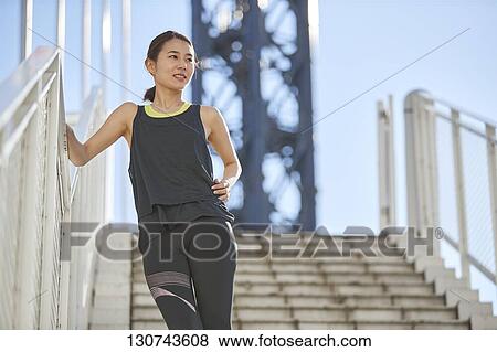Stock Photo - Young Japanese Woman Taking A Break During Jogging. Fotosearch