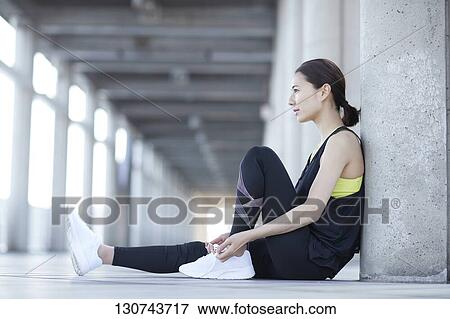 Stock Photo - Young Japanese Woman Taking A Break During Jogging. Fotosearch