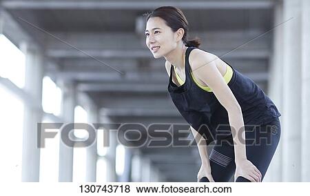 Stock Photo - Young Japanese Woman Taking A Break During Jogging. Fotosearch
