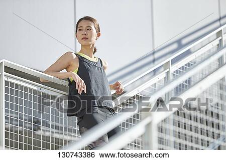 Stock Photograph - Young Japanese Woman Taking A Break During Jogging. Fotosearch