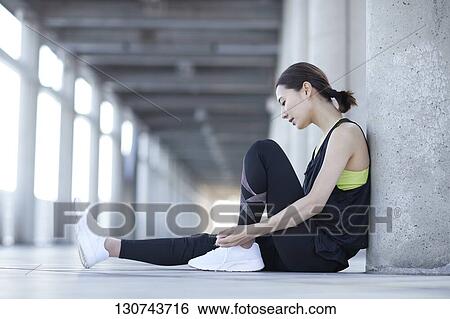 Stock Photograph - Young Japanese Woman Taking A Break During Jogging. Fotosearch