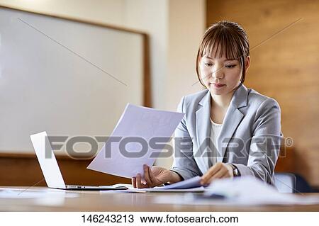 Stock Image - Young Japanese woman working. Fotosearch