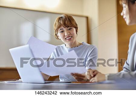 Stock Image - Young Japanese women working. Fotosearch