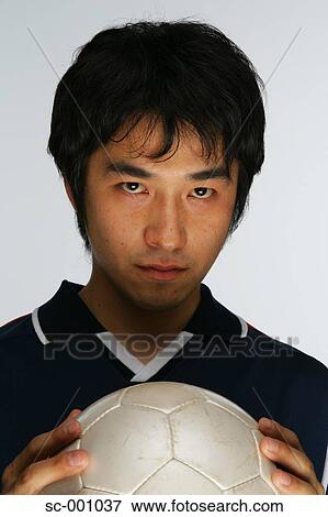 Determined soccer player holding ball to chest View Large Photo Image Stock Photo - Determined soccer player holding ball to chest. Fotosearch