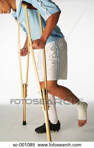 Stock Photography - Injured soccer player using crutches. Fotosearch