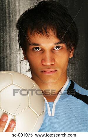 Stock Photography - Portrait of soccer player holding ball. Fotosearch
