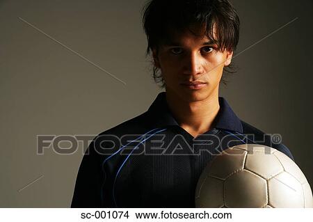 Picture - Soccer player holding ball. Fotosearch