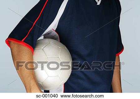 Stock Image - Soccer player holding ball. Fotosearch