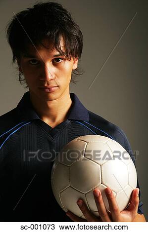 Stock Image - Soccer player holding ball. Fotosearch