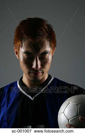 Stock Photo - Soccer player holding ball. Fotosearch