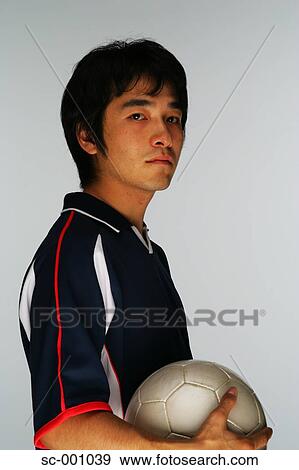 Stock Photo - Soccer player holding ball. Fotosearch
