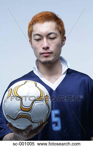Stock Photography - Soccer player holding ball. Fotosearch