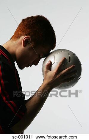 Soccer player holding ball to head View Large Photo Image Stock Image - Soccer player holding ball to head. Fotosearch