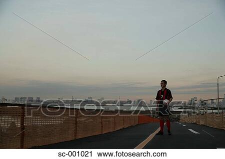 Stock Image - Soccer player on road. Fotosearch
