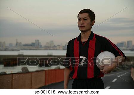 Soccer player on road View Large Photo Image Stock Photo - Soccer player on road. Fotosearch