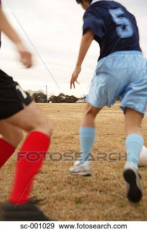 Stock Photo - Two soccer players challenging for ball. Fotosearch