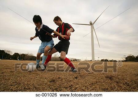 Stock Photograph - Two soccer players challenging for ball. Fotosearch