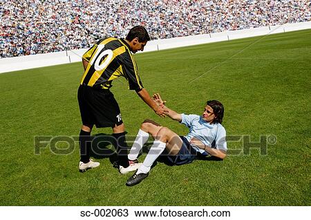 Soccer player helping opponent View Large Photo Image Stock Image - Soccer player helping opponent. Fotosearch