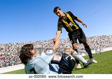 Soccer player helping opponent View Large Photo Image Stock Photography - Soccer player helping opponent. Fotosearch