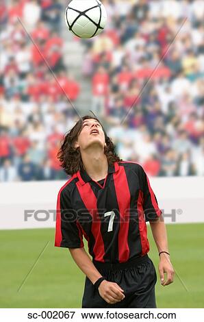 Soccer player juggling ball on head View Large Photo Image Stock Photo - Soccer player juggling ball on head. Fotosearch