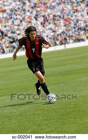 Soccer player running with ball View Large Photo Image Stock Image - Soccer player running with ball. Fotosearch