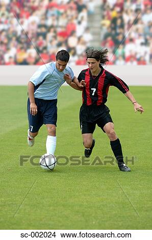Picture - Soccer players battling for ball. Fotosearch