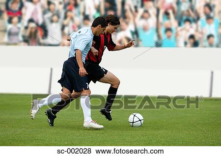 Stock Photo - Soccer players battling for ball. Fotosearch