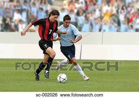 Soccer players battling for ball View Large Photo Image Stock Photograph - Soccer players battling for ball. Fotosearch