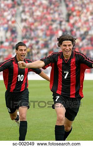 Two teammates celebrating View Large Photo Image Stock Photo - Two teammates celebrating. Fotosearch
