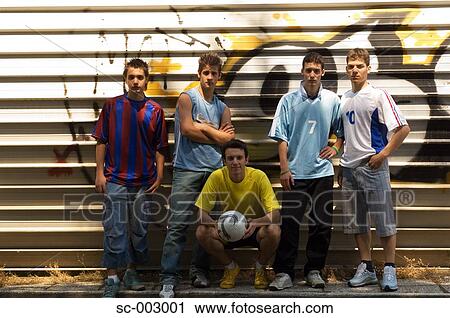 Stock Image - Group of teenage soccer friends against graffiti wall. Fotosearch