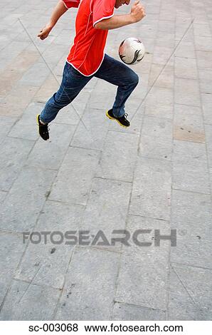 Man running with soccer ball in town square View Large Photo Image Stock Photo - Man running with soccer ball in town square. Fotosearch