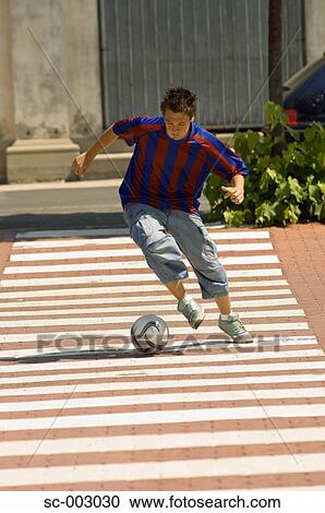 Teenage boy dribbling soccer ball in town View Large Photo Image Stock Image - Teenage boy dribbling soccer ball in town. Fotosearch