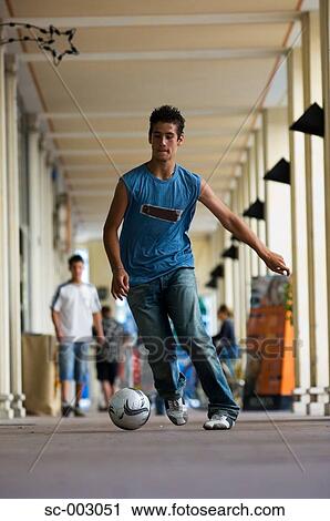 Teenage boy dribbling soccer ball in town View Large Photo Image Stock Image - Teenage boy dribbling soccer ball in town. Fotosearch
