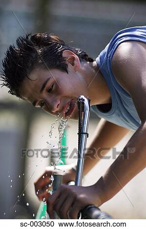 Teenage boy drinking water from fountain View Large Photo Image Stock Image - Teenage boy drinking water from fountain. Fotosearch