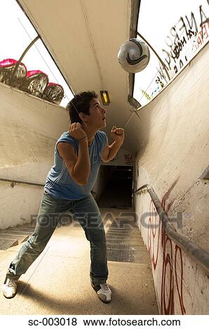 Stock Photo - Teenage boy heading ball in underpass. Fotosearch