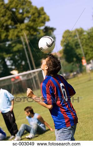 Teenage boy juggling soccer ball with head View Large Photo Image Stock Photo - Teenage boy juggling soccer ball with head. Fotosearch